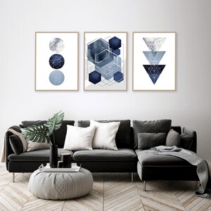May include: Three framed abstract geometric prints in shades of blue and silver. The prints feature circles, hexagons, and triangles.
