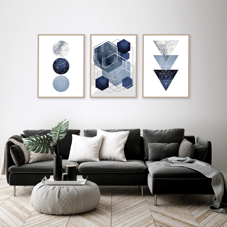 May include: Three framed abstract geometric prints in shades of blue and silver. The prints feature circles, hexagons, and triangles.