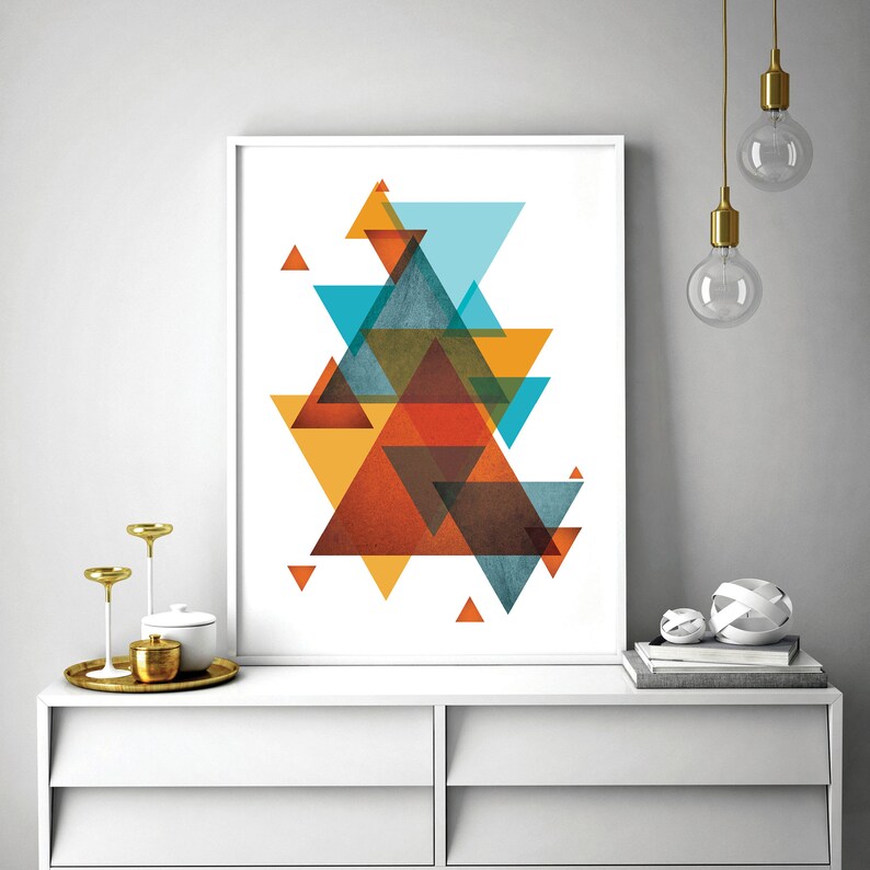 K&ouml;nnte beinhalten: Abstrakter geometrischer Kunstdruck mit &uuml;berlappenden Dreiecken in Orange-, Gelb-, Blau- und Braunt&ouml;nen. Der Druck ist in einem wei&szlig;en Rahmen gerahmt und h&auml;ngt an einer wei&szlig;en Wand.