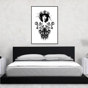 May include: Monochrome art print featuring a woman adorned with a floral crown and a decorative floral pattern. The framed artwork hangs above a black bed frame with white bedding. The room has white walls and a white bedside table.