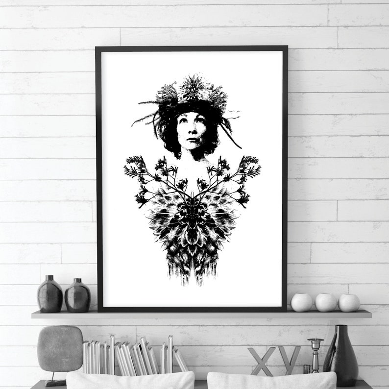 May include: Monochrome art print depicting a woman adorned with a floral crown and a detailed chest design. The artwork is framed in black and mounted on a white wall. The high-contrast image creates a bold visual statement, suitable for home decor.