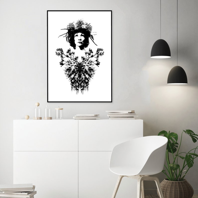 May include: Monochrome art print depicting a woman adorned with a floral crown and intricate chest design. The artwork is framed in black, mounted on a white wall. This print offers a bold contrast, perfect for adding a touch of artistic style to a room.