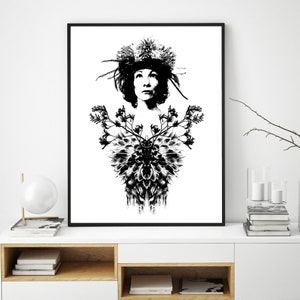 May include: Monochrome art print featuring a woman adorned with a floral crown and a symmetrical floral design. The artwork is presented in a black frame. The print is displayed on a white cabinet, creating a striking contrast.