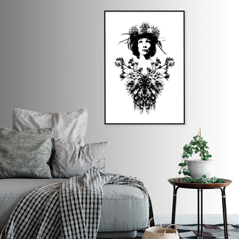 May include: Monochrome art print featuring a woman adorned with a floral headdress and a decorative chest design. The artwork is framed in black and displayed on a white wall. A stylish piece of wall decor.