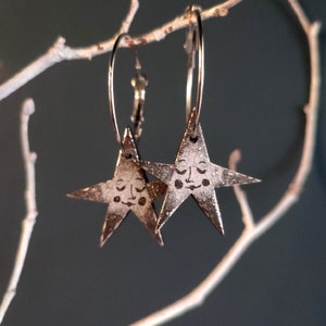 Star Earrings - Silver & Black. Hoop earrings featuring hanging stars with sweet sleepy faces. Handmade laser-cut and decoupaged jewellery