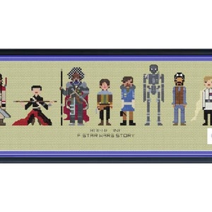 Pode incluir: Um padrão de ponto cruz com personagens do filme Rogue One: Uma História Star Wars. Os personagens são representados em um estilo pixelado, com um fundo bege e uma borda azul. Os personagens incluem Jyn Erso, Cassian Andor, Chirrut Îmwe, Baze Malbus, K-2SO e Bodhi Rook.
