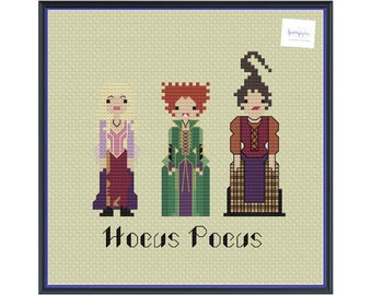 Peut inclure: Motif de point de croix représentant trois personnages du film "Hocus Pocus". Les personnages sont stylisés en pixels, avec le titre du film en dessous. Le fond est beige clair, et l'image est encadrée d'un bord bleu foncé.