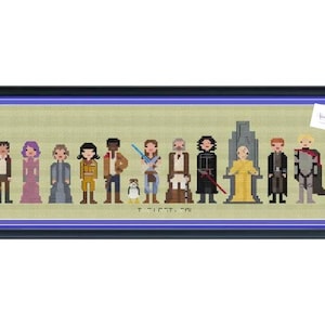 Pode incluir: Obra de arte em ponto cruz com personagens de uma série de filmes de ficção científica. A peça emoldurada mostra figuras pixeladas em várias cores, incluindo marrom, roxo e amarelo, em um fundo verde claro. A obra de arte está em uma moldura preta.