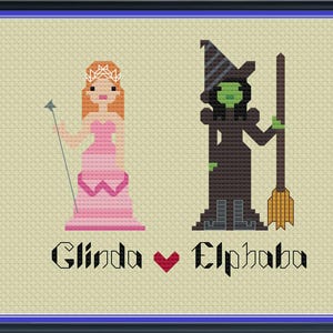 Pode incluir: Padrão de ponto cruz com Glinda e Elphaba do musical Wicked. O padrão mostra Glinda em um vestido rosa e Elphaba em um chapéu verde e um vestido preto.