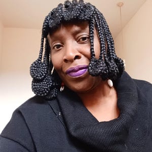 Peut inclure: Une femme à la peau foncée porte un pull à col roulé noir et une coiffure tressée noire avec des perles décoratives. Ses cheveux sont coiffés de manière unique avec des tresses qui sont attachées ensemble en petits nœuds.