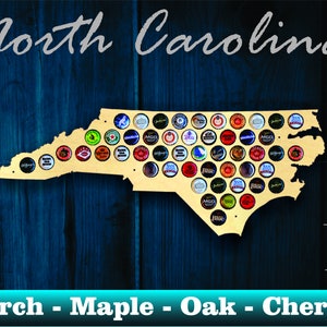 May include: A wooden cutout of the state of North Carolina, designed to hold bottle caps. The cutout is made of birch, maple, oak, or cherry wood. The cutout is displayed on a blue wooden background. The text "North Carolina" is written above the cutout. The text "MADE IN USA" is written below the cutout, with a small American flag image next to it.