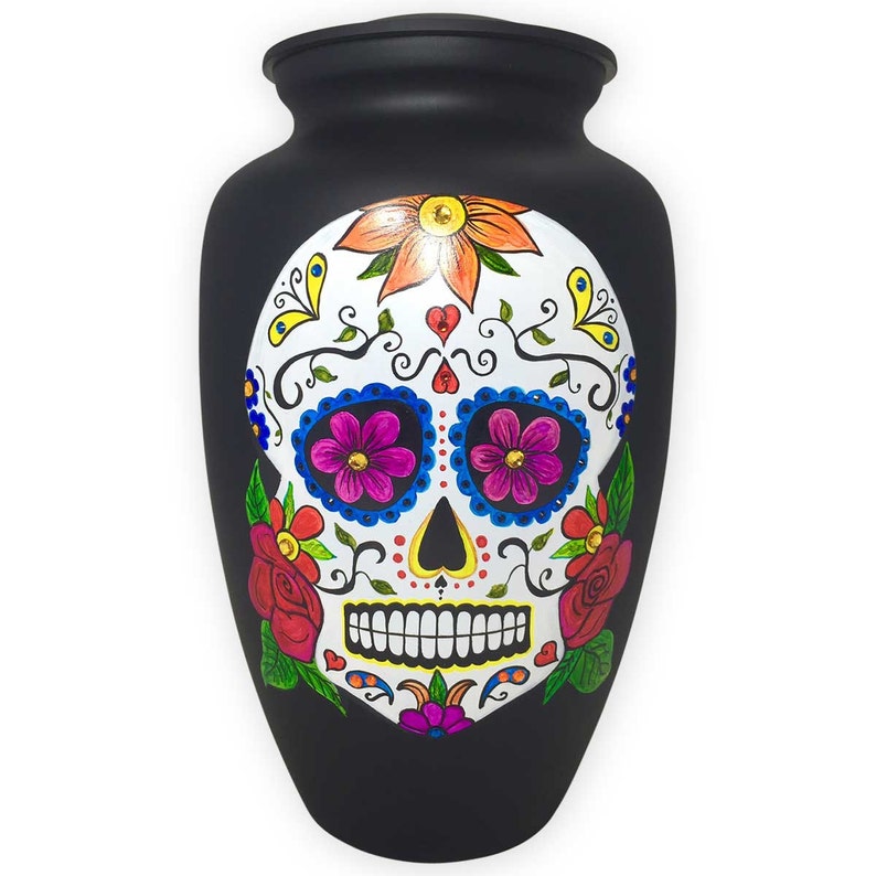 Adult-sized metal urn painted all-over black with image of sugar skull on urn front.  The skull is white with multi-colored flowers and authentic crystals.  Personalize the urn with hand painted name and dates, in white, on urn back.