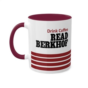 Peut inclure: Une tasse à café en céramique blanche avec un intérieur et une poignée marrons. La tasse présente un texte noir qui dit "Drink Coffee READ BERKHOF" avec trois bandes marrons en bas.