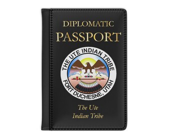 Könnte beinhalten: Schwarzer Leder-Reisepass-Etui mit goldener Aufschrift "Diplomatischer Reisepass". Die Vorderseite zeigt ein rundes Siegel mit den Worten "The Ute Indian Tribe Fort Duchesne, Utah". Unter dem Siegel befindet sich der Text "The Ute Indian Tribe".