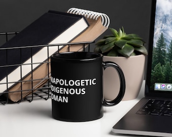 May include: Black coffee mug with white text that reads "Unapologetic Indigenous Woman".