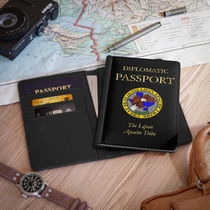 May include: Black leather passport holder with the text "DIPLOMATIC PASSPORT" and "The Lipan Apache Tribe" in gold lettering. The holder features a seal with an eagle and the text "SEAL OF THE LIPAN APACHE TRIBE GREAT" in gold lettering.