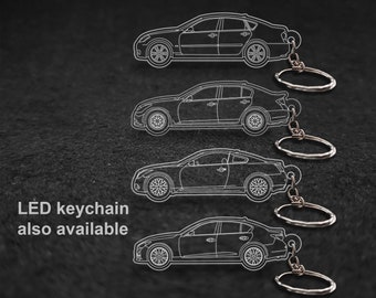 Peut inclure: Quatre porte-clés de voiture argentés de différentes tailles avec porte-clés LED également disponibles. Les porte-clés sont soulignés en blanc sur un fond noir.
