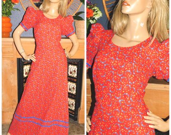 May include: A vintage red maxi dress with a floral pattern and short, puffed sleeves. The dress features blue trim on the sleeves and hemline. The dress is displayed on a mannequin.