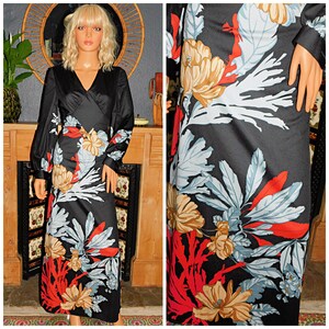 May include: A long-sleeved black dress with a floral print featuring red, white, blue, and brown flowers. The dress has a V-neckline and a wrap-style bodice.