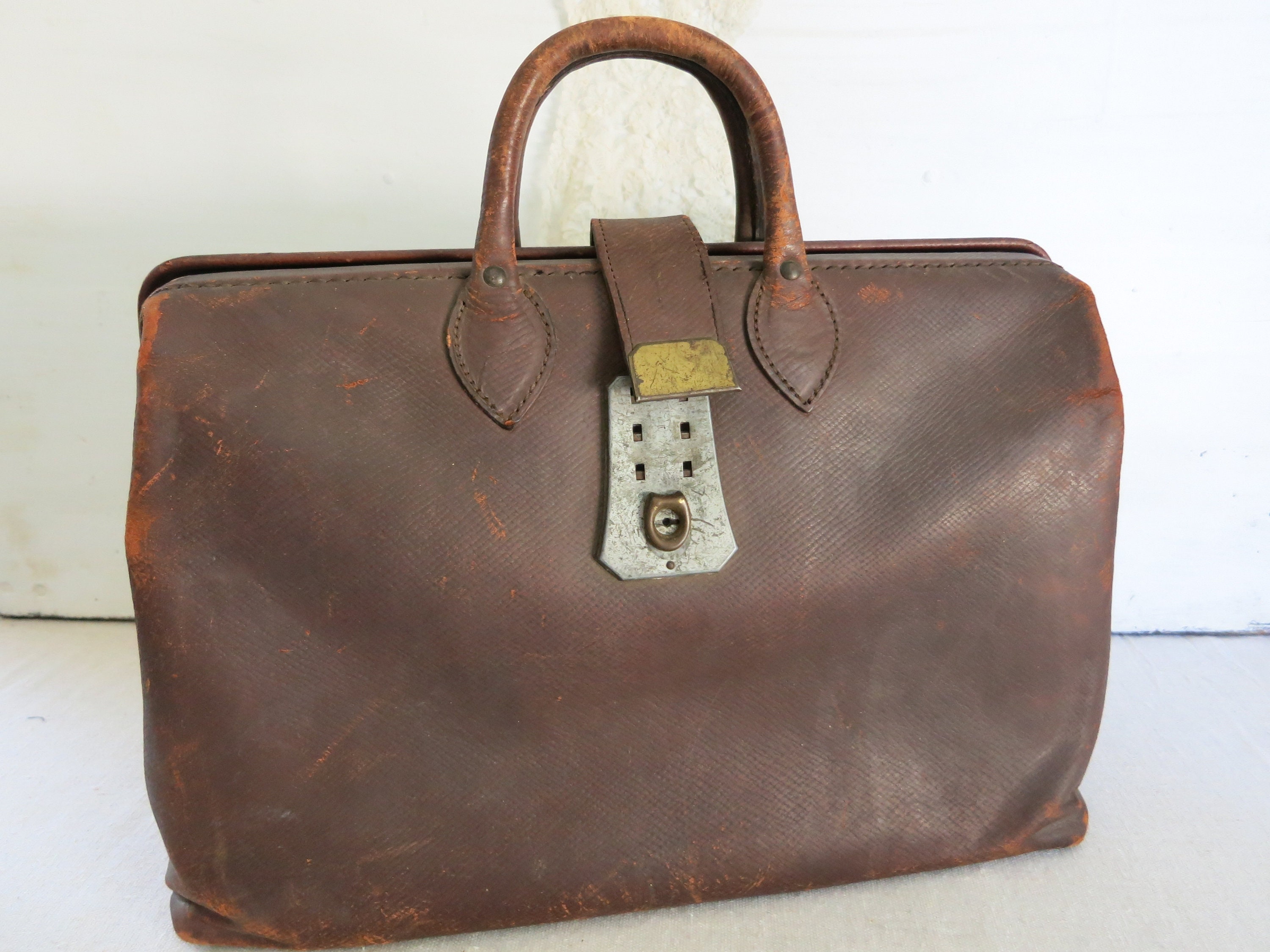 An old battered leather medical doctors bag containing a