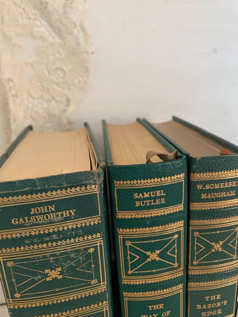 May include: Three vintage hardcover books with green covers and gold lettering. The spines display author names: John Galsworthy, Samuel Butler, and W. Somerset Maugham. Decorative gold patterns adorn the covers.
