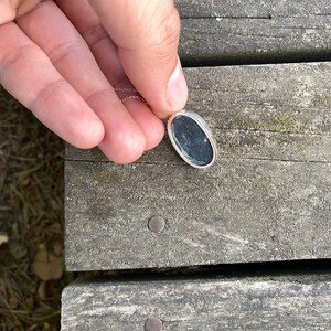 Peut inclure: Un collier en cha&icirc;ne argent avec un pendentif ovale noir.