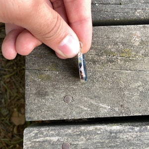 Peut inclure: Un pendentif en argent avec une pierre bleu fonc&eacute; et blanche. Le pendentif est de forme ovale et poss&egrave;de une b&eacute;li&egrave;re en argent.