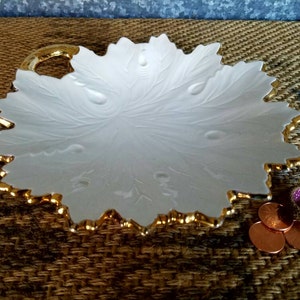 May include: White ceramic leaf-shaped serving dish with a gold rim and a handle. The dish has a raised design of leaves and veins.