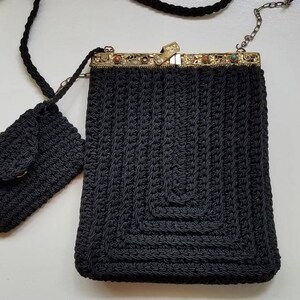 May include: A black crocheted purse with a metal clasp and a matching smaller purse. The purse has a chain strap.