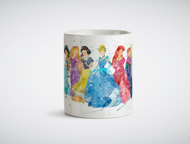 May include: White ceramic mug with a watercolor illustration of seven Disney princesses in their iconic dresses. The princesses are arranged in a line, with Cinderella in the center. The background is a light blue watercolor wash.