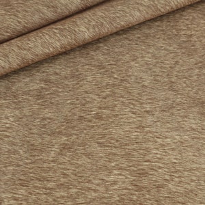 May include: Close-up of a brown fabric with a textured, fuzzy surface.