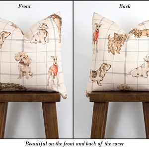 Peut inclure: Une housse de coussin de couleur cr&egrave;me avec un motif quadrill&eacute; et une illustration r&eacute;p&eacute;t&eacute;e de chiens de diff&eacute;rentes races. Les chiens sont dessin&eacute;s en brun, noir et blanc avec des accents rouges. La housse de coussin est pr&eacute;sent&eacute;e sur l'avant et l'arri&egrave;re.