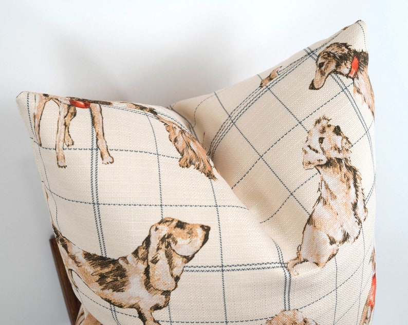 Peut inclure: Un oreiller beige avec un motif &agrave; carreaux bleu et blanc et une illustration r&eacute;p&eacute;t&eacute;e de chiens bruns et blancs.