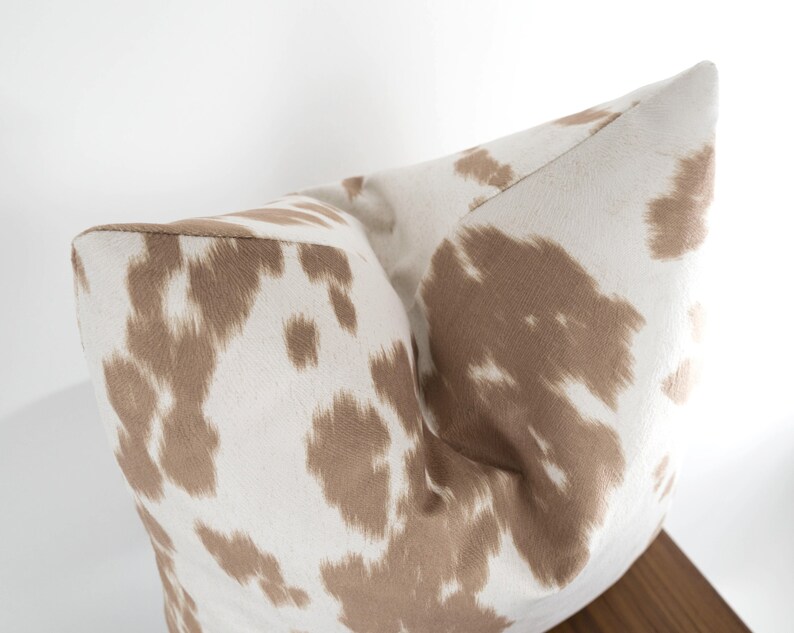 May include: A white and brown patterned throw pillow with a soft, plush texture.