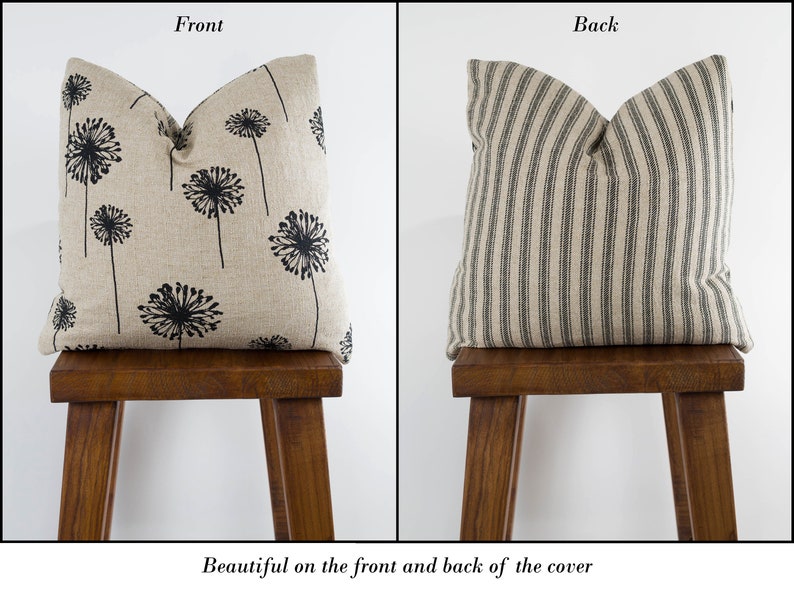 May include: A decorative pillow with a black dandelion print on the front and black and white stripes on the back. The pillow is sitting on a wooden stool.