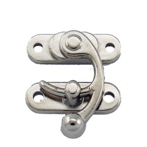 May include: Silver-toned metal hook and eye clasp with a rounded knob. The clasp has two holes on each side for attaching to fabric.