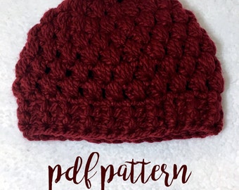 May include: A burgundy crocheted beanie hat with a textured stitch pattern. The hat is on a white surface with the text "pdf pattern" written below it.