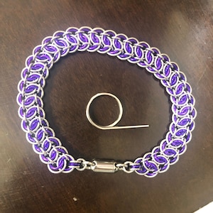 May include: A silver and purple chainmail necklace with a magnetic clasp.