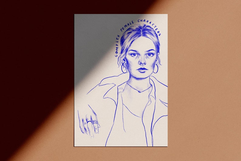 Op de afbeelding: Een blauwe inkttekening van een vrouw met de tekst "COMPLEX FEMALE CHARACTERS" in een cirkelvormig patroon boven haar hoofd. De vrouw draagt oorringen en een ketting. Haar hand rust op de onderkant van de afbeelding, met ringen aan haar vingers.