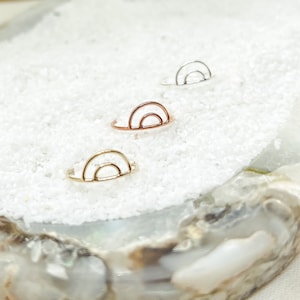 Könnte beinhalten: Drei minimalistische Regenbogenringe in Silber, Gold und Roségold. Die Ringe sind zart und schlicht, mit einem dünnen Drahtdesign.
