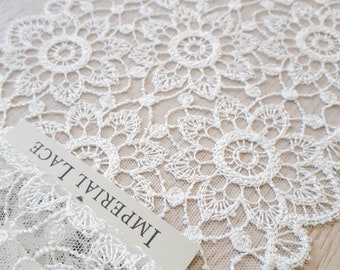 May include: White lace trim with a scalloped edge and a delicate floral pattern. The trim is labeled "Imperial Lace".