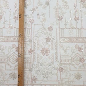 May include: White and pink beaded fabric with a geometric pattern. The fabric is sheer and has a delicate, feminine look.