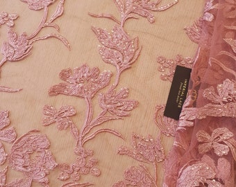May include: Pink floral lace fabric with a delicate pattern and a small tag that reads "Imperial Lace".