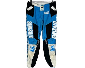 May include: Blue and black motocross trousers with white "SINISALO" text on the sides. The trousers have a white and blue stripe down the side and a white "S" logo on the legs.