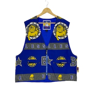 May include: Blue sleeveless vest with a zipper closure. The vest has a repeating pattern of yellow bulldogs with the text "Bulldog" and "Less" on a blue background. The vest has a gray stripe with the text "ellesse" on it.