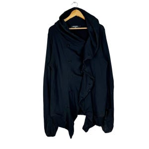 May include: Black hooded cardigan with a draped, asymmetrical design and button closures. The cardigan has a long, flowing silhouette and a relaxed fit.