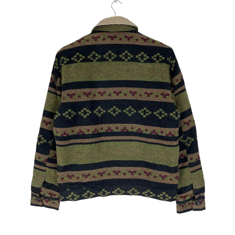 May include: A green, black and brown patterned fleece jacket with a zip closure. The jacket has a southwestern style design.