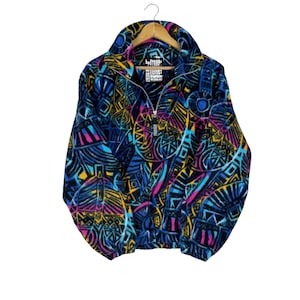 May include: A vintage fleece jacket with a vibrant, geometric pattern in blue, yellow, pink, and black. The jacket has a high collar, a half-zip closure, and the brand name "SURF LIGE" is visible on the label.