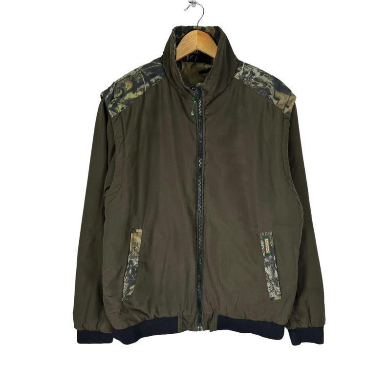May include: A green camouflage jacket with a zip fastening and a black ribbed collar and cuffs.