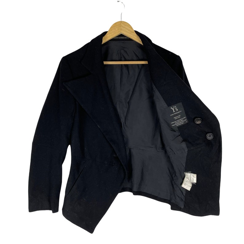 May include: A black double-breasted blazer with a long, asymmetrical hemline. The blazer has a Y's for Yohji Yamamoto label on the inside.